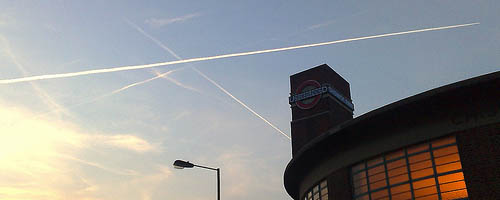 Chiswick Park tube station with contrails.